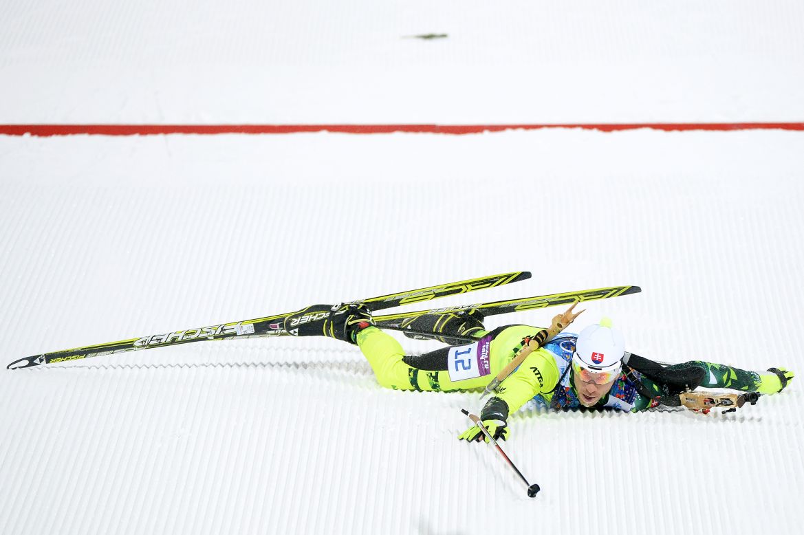 Biathlete Matej Kazar of Slovakia falls over the finish line during the mixed relay event on February 19.