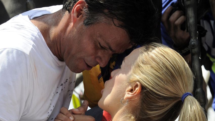 Leopoldo Lopez, an ardent opponent of Venezuela's socialist government facing an arrest warrant after President Nicolas Maduro ordered his arrest on charges of homicide and inciting violence, kisses his wife Lilian Tintori, during a demonstration before turning himself in to authorities, in Caracas on February 18, 2014. Fugitive Venezuelan opposition leader Lopez, blamed by Maduro for violent clashes that left three people dead last week, appeared at an anti-government rally in eastern Caracas and quickly surrendered to the National Guard after delivering a brief speech. AFP PHOTO / LEO RAMIREZLEO RAMIREZ/AFP/Getty Images
