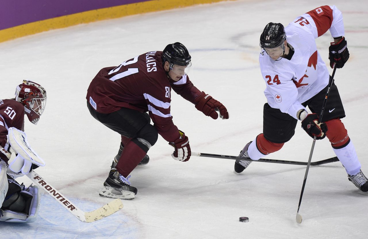 Corey Perry (R) scored in the third period to give Canada a 2-1 victory over Latvia and put the three-time defending champion through to the semifinals. 