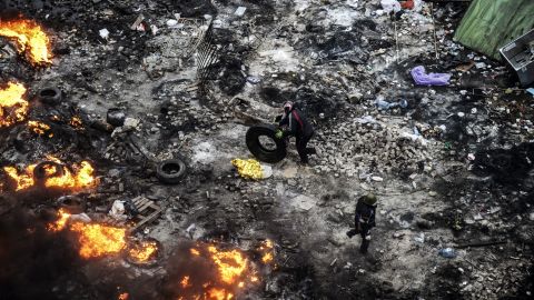 Un manifestante lleva un neumático en medio de la quema de barricadas , el 20 de febrero.