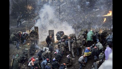 Fuegos explotan sobre los manifestantes cerca de Plaza de la Independencia , el 20 de febrero.