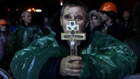 Un manifestante sostiene un crucifijo mientras ora en la Plaza de la Independencia.