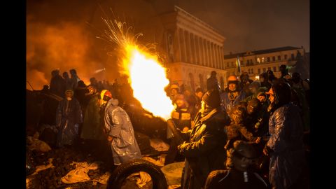Los manifestantes utilizan un cañón de aire comprimido para lanzar un cóctel molotov hacia líneas de la policía en la Plaza de la Independencia el 19 de febrero.