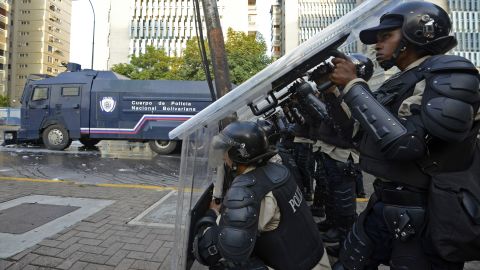 Members of the National Police protect themselves during a protest in Caracas on February 19.