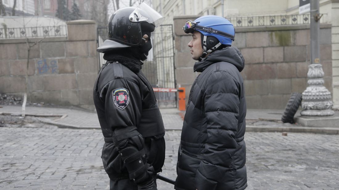 A high-ranking police officer, left, and a representative for the protesters speak with each other near the Cabinet of Ministers in Kiev on February 20.