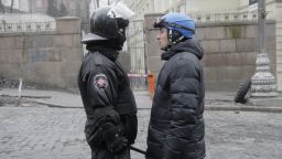 A high-ranking police officer, left, and a representative for the protesters speak with one another near the Cabinet of Ministers in Kiev on February 20.