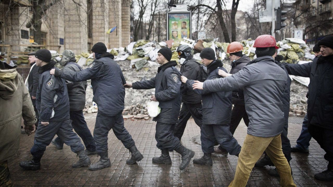 Captured police officers are led away by protesters in Kiev on February 20.
