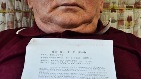 Jang Chun holds a letter and several photos of his family in North Korea through the Red Cross.