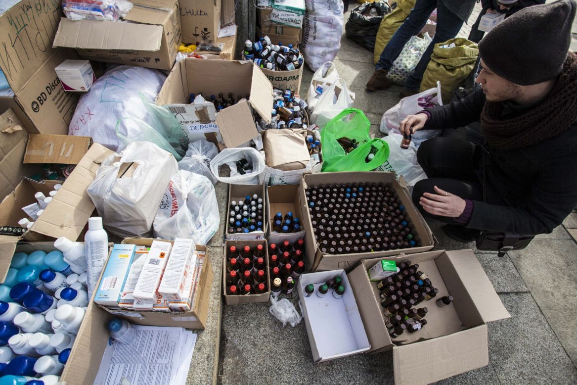 An unidentfied man sorts through items outside the Mykhailovsky Cathedral in Kyiv. The cathedral opened its doors for protesters wounded during the clashes with riot police Wednesday and Thursday.