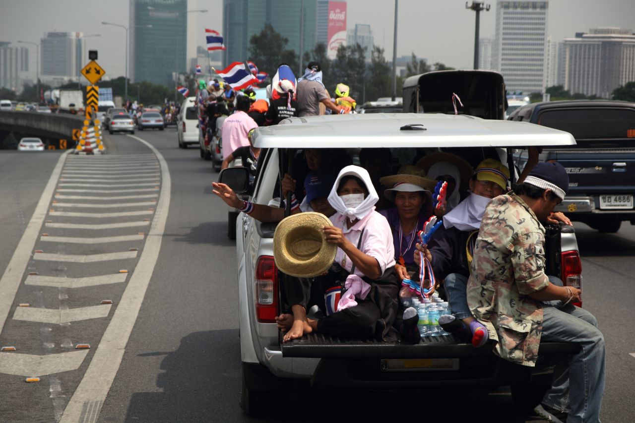 A convoy of trucks carrying protesters sets off for a demonstration at the defense ministry complex in Bangkok on February 19.