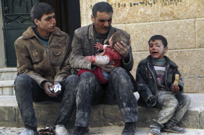 Un hombre sostiene a un bebe que sobrevivió lo que activistas dicen que fue un ataque aéreo perpetrado por partidistas de al-Assad, el viernes 14 de febrero en Alepo. 