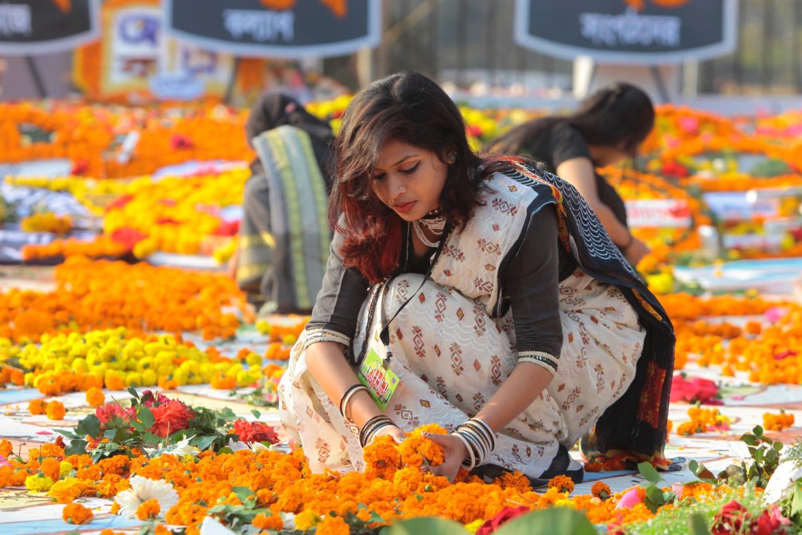 FEBRUARY 21 - DHAKA, BANGLADESH: A Bangladeshi woman decorates the Shaheed Minar, or Martyr's Monuments, on International Mother Language Day. A number of students died during the movement in 1952, defending the recognition of Bangla as a state language of the former East Pakistan, now Bangladesh. The day is now observed across the world to promote linguistic and cultural diversity and multilingualism.