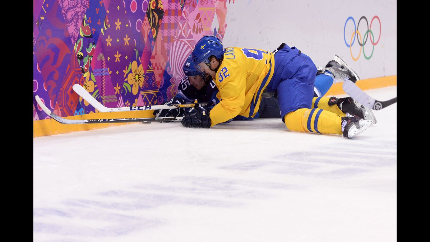 Finland's Sami Vatanen, left, vies for the puck with Sweden's Gabriel Landeskog during the men's hockey semifinal on February 21.