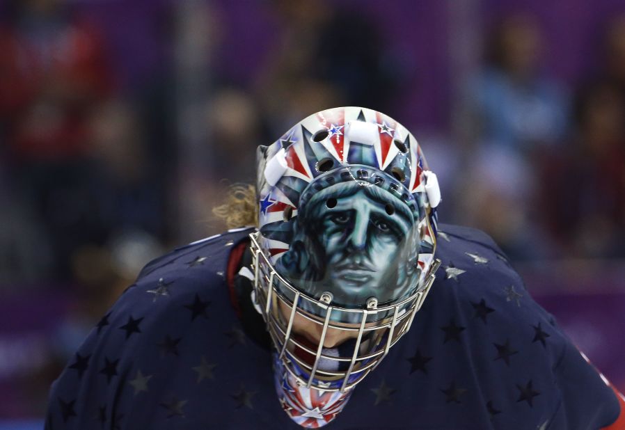 While U.S. hockey goalkeeper Jessie Vetter looks down during a break in play, her helmet reveals a scary version of Lady Liberty.