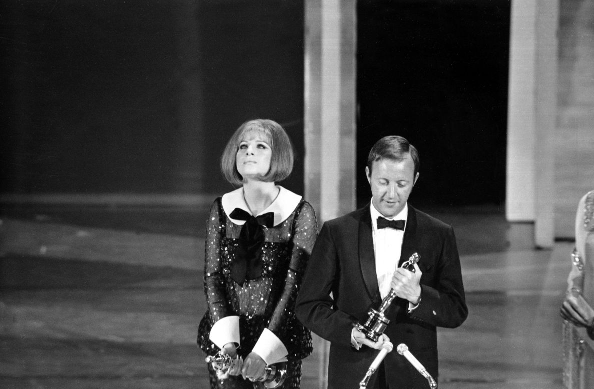 In 1969 the Academy makes history with a tie: Barbra Streisand is named best actress for her role in "Funny Girl" and Katharine Hepburn for her role in "The Lion In Winter." Streisand is seen here beside British director Anthony Harvey, who accepts the award on Hepburn's behalf.