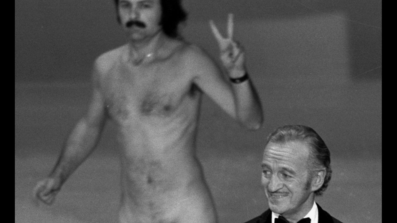 Oscar presenter David Niven isn't quite sure what's happening behind him as a streaker crosses the stage near the end of the 1974 Academy Awards. The streaker later identifies himself as Robert Opel.  