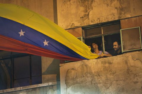 A woman waves a Venezuelan flag out of her Caracas window on February 21.