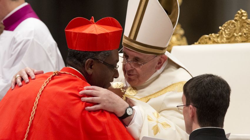 Newly-elected Cardinal Chibly Langlois Bishop of Les Cayes, Haiti, is hugged by Pope Francis after he received the red three-cornered biretta hat during a consistory inside the St. Peter's Basilica at the Vatican, Saturday, Feb.22, 2014. (AP Photo/Alessandra Tarantino)