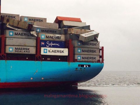 Containers lay damaged and precariously perched on the deck of the ship.
