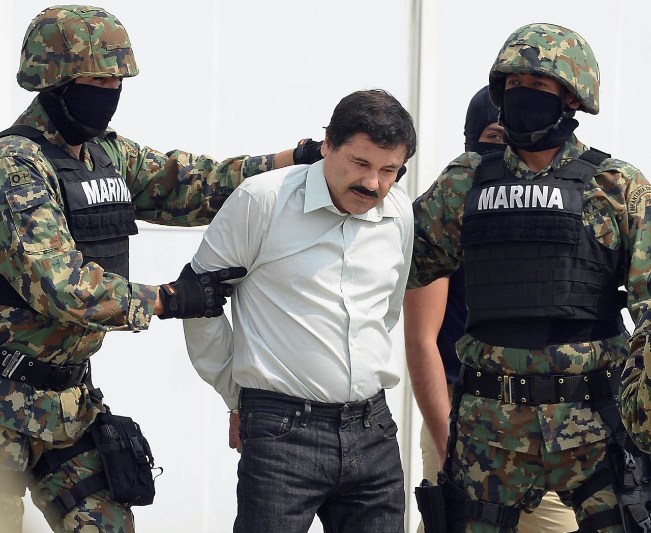 Mexican drug trafficker Joaquin "El Chapo" Guzman is escorted by Mexican marines as he is presented to the press on February 22, in Mexico City. 