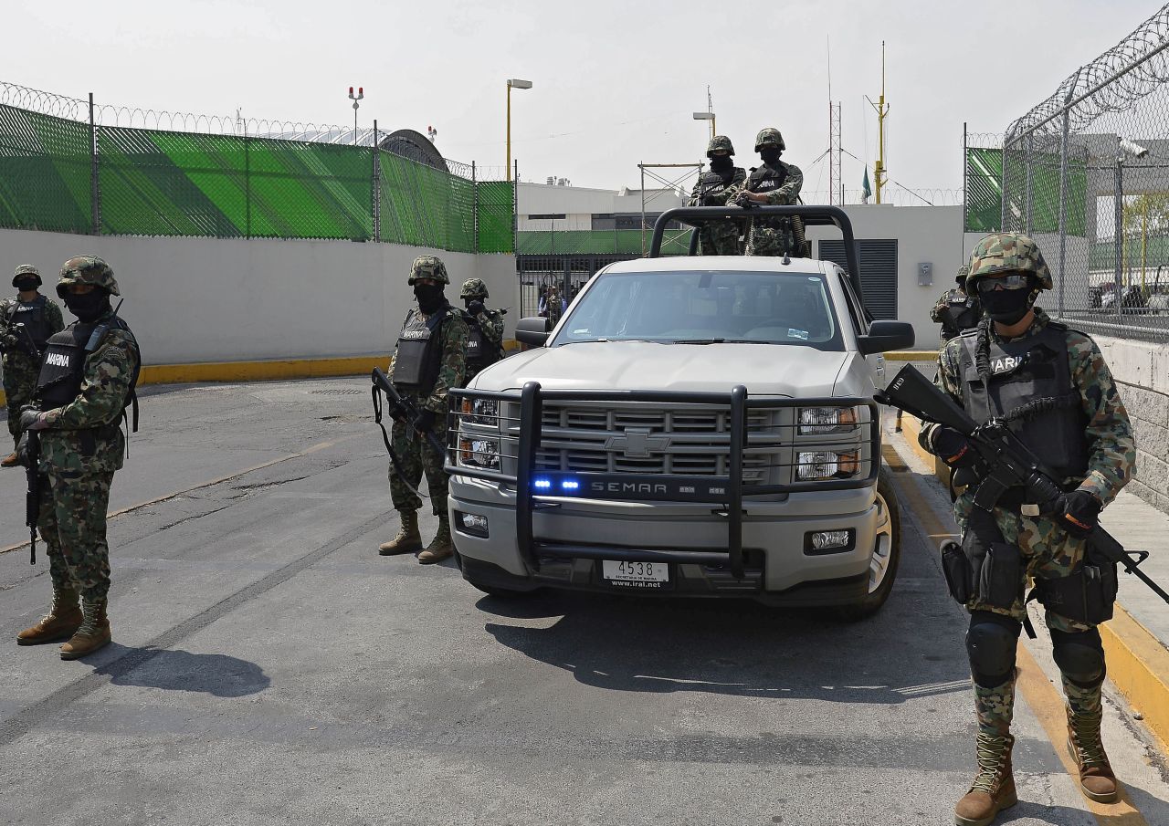 Marines stand guard as Guzman is presented to the press.