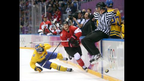 Chris Kunitz of Canada delivers a high stick to Marcus Kruger of Sweden during the hockey game on February 23.