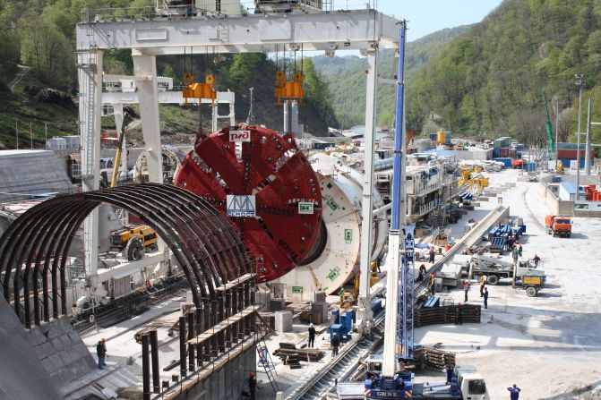 Six huge boring machines (like the one pictured) and 14 "harvesters", which transport the rubble and soil away from the mountain face, along with various drilling and blasting methods were used to drive 30 kilometers of tunnel through the mountains.