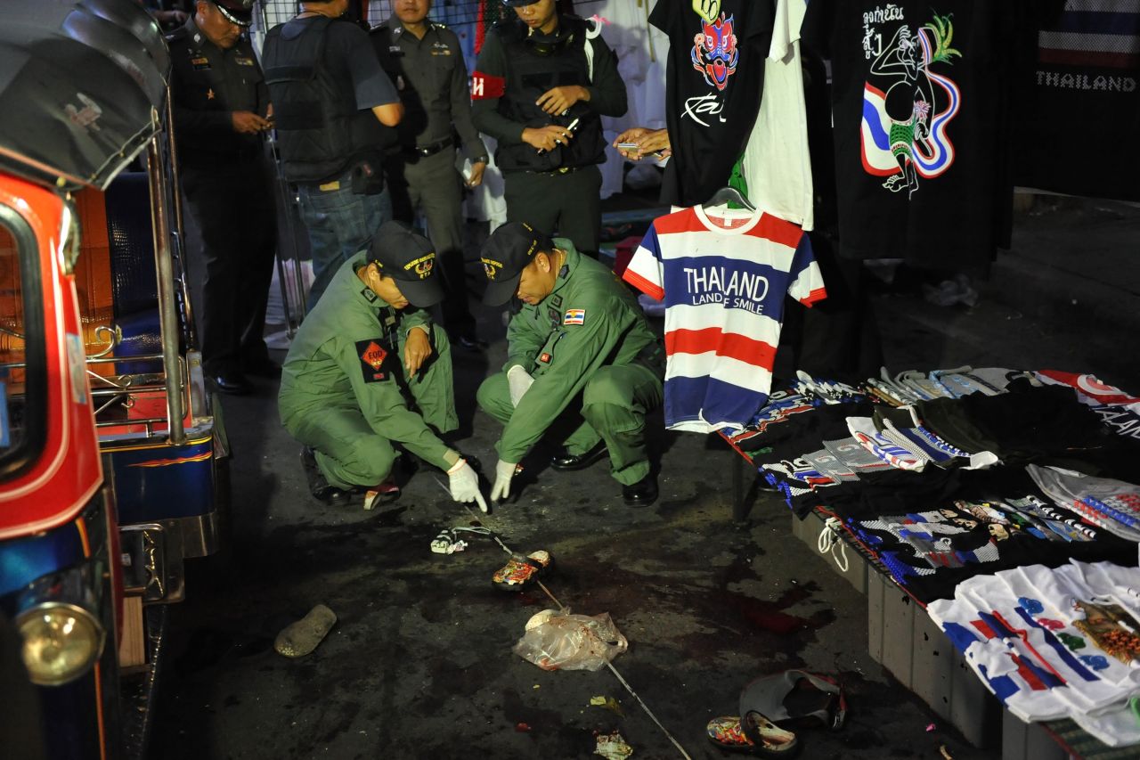 A bomb squad examines the scene of an explosion at an anti-government rally in Bangkok on February 23. Two children and a woman were killed and more than 20 injured outside a shopping mall. Protesters have been calling for the ouster of Prime Minister Yingluck Shinawatra, whom they allege is a puppet of her billionaire brother, the deposed, exiled former Prime Minister Thaksin Shinawatra.