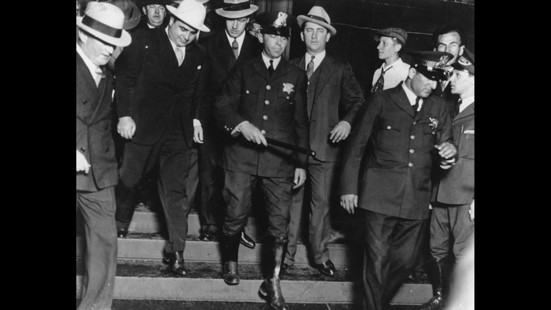 Al Capone -- on the left, wearing the all-white hat --  leaves a Chicago courtroom in the custody of U.S. marshals in October 1931. Capone ran gambling, prostitution and bootlegging operations across Chicago until he was indicted in 1931 for tax evasion. He was convicted and spent the next 11 years in prison.