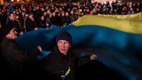 People wave a large Ukrainian flag in Independence Square on Sunday, February 23.