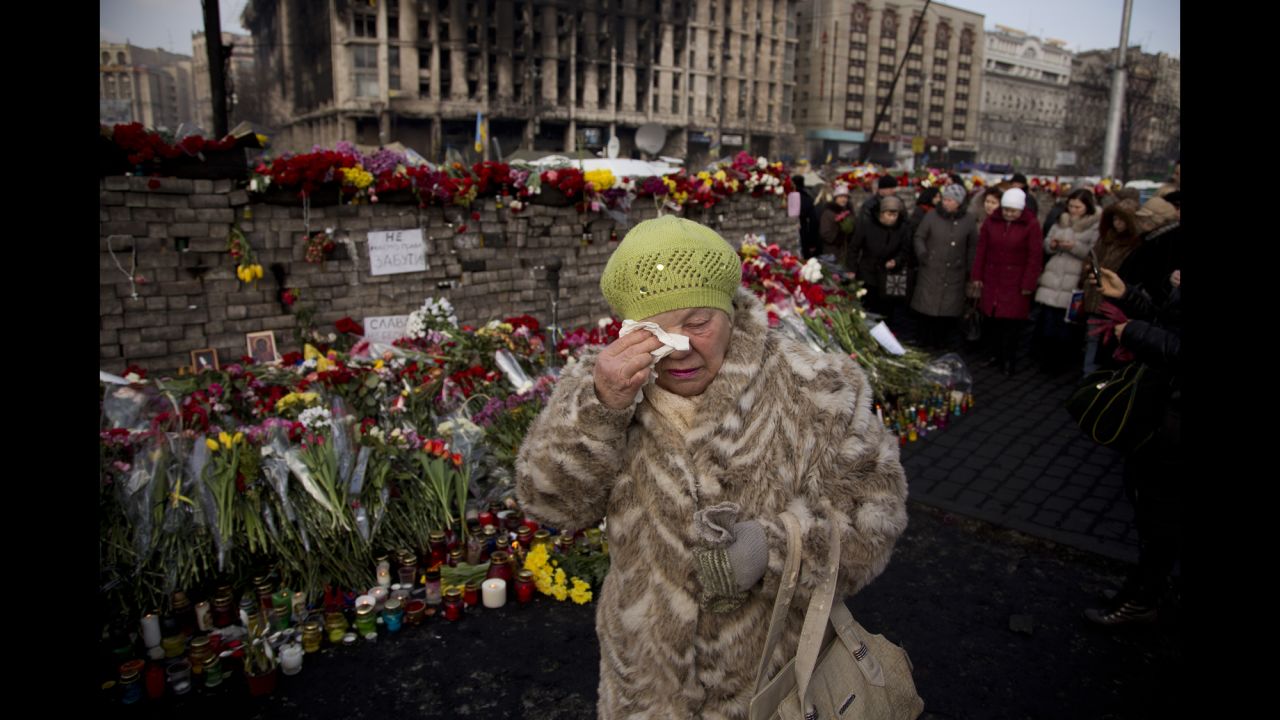 A woman cries February 24 near a memorial for the people killed in Kiev.