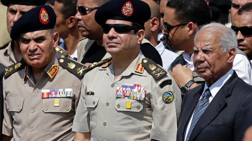 [FILE] Egypt's Defense Minister Gen. Abdel-Fattah el-Sissi, center, Egyptian Prime Minister Hazem el-Beblawi, right, and army's Chief of Staff Lt. Gen. Sedki Sobhi, left, attend the funeral of Giza Police Gen. Nabil Farrag in Cairo, Egypt. 