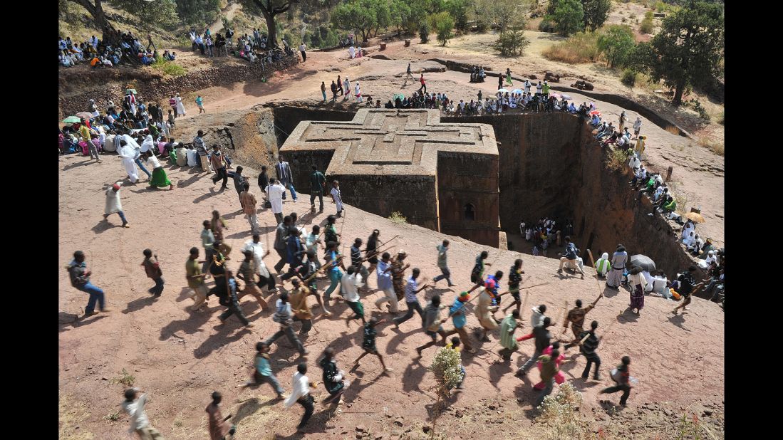 Ethiopian Orthodox Christians dance near to the rock-hewn church Bete Giyorgis during the annual festival of Timkat in Lalibela, Ethiopia. Bete Giyorgis is one of the 13th century-era medieval, monolithic cave churches in Lalibela.