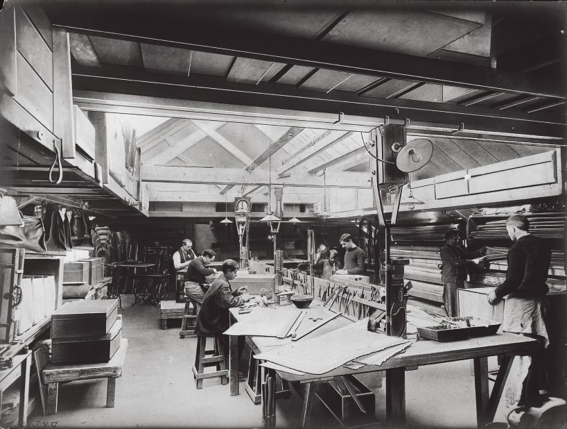 Artisans work in a room bathed in natural light in this image from 1902. This is where fine touches that distinguished Vuitton products were made. 