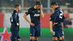 PIRAEUS, GREECE - FEBRUARY 25: (L-R) Wayne Rooney, Michael Carrick and Robin van Persie of Manchester United react as they restart the game after conceding the first goal during the UEFA Champions League Round of 16 first leg match between Olympiacos FC and Manchester United at Karaiskakis Stadium on February 25, 2014 in Piraeus, Greece. (Photo by Michael Regan/Getty Images)
