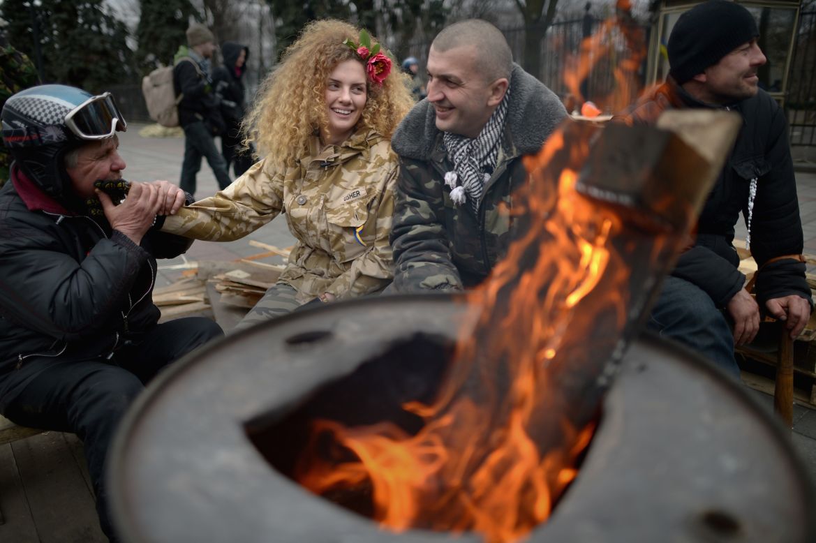 FEBRUARY 26 - KIEV, UKRAINE: Anti-Yanukovych demonstrators sit by a brazier outside the Ukrainian parliament in Kiev. The<a href="http://edition.cnn.com/2014/02/26/world/europe/ukraine-politics/index.html?hpt=hp_t1"> country's interim leaders are due to form a unity government</a>, as UK and U.S. foreign ministers and the IMF meet to discuss emergency financial assistance for the country. 