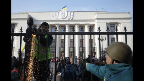 Protesters remove a fence that surrounds Ukraine's parliament in Kiev on February 26.