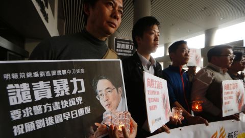Protesters hold a picture of former Ming Pao editor Kevin Lau outside a hospital in Hong Kong.