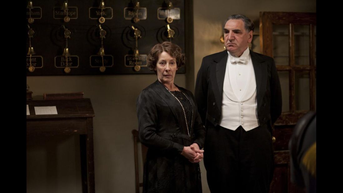Carson wears a white waist coat and a white tie similar to those worn by Lord Grantham. Differentiating the butler from the gentlemen was all about the quality of the cloth and tailoring, said Jeff Groff, one of the exhibition curators. Mrs. Hughes' silhouettes are similar to those worn by the Dowager Countess but much plainer and simpler.