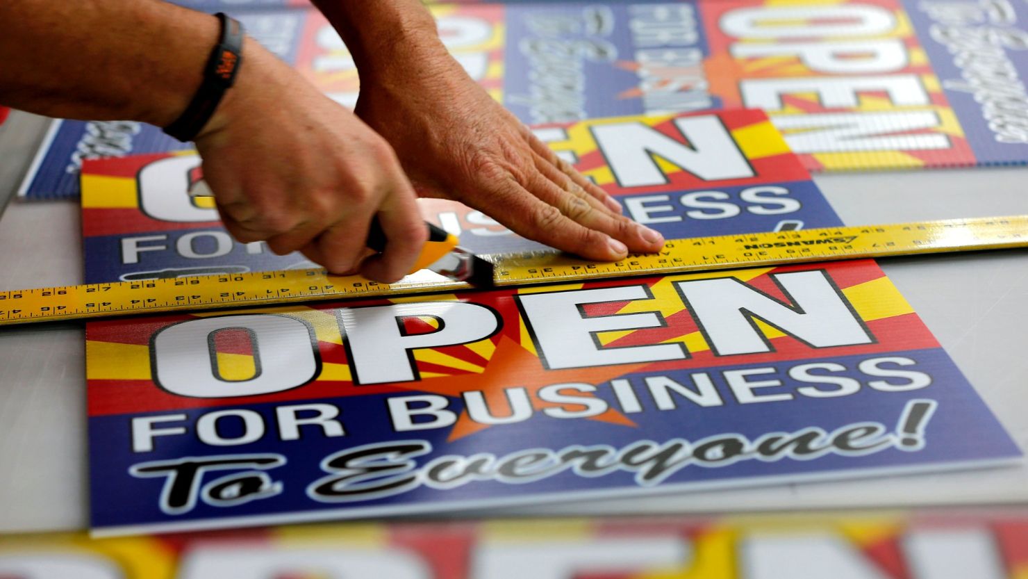 Tom Cushing, a production expert at Fast Signs in Phoenix, Arizona, cuts down a sheet of anti-Senate Bill 1062 signs that read "Open For Business To Everyone" on Wednesday before Gov. Jan Brewer vetoed the controversial measure.