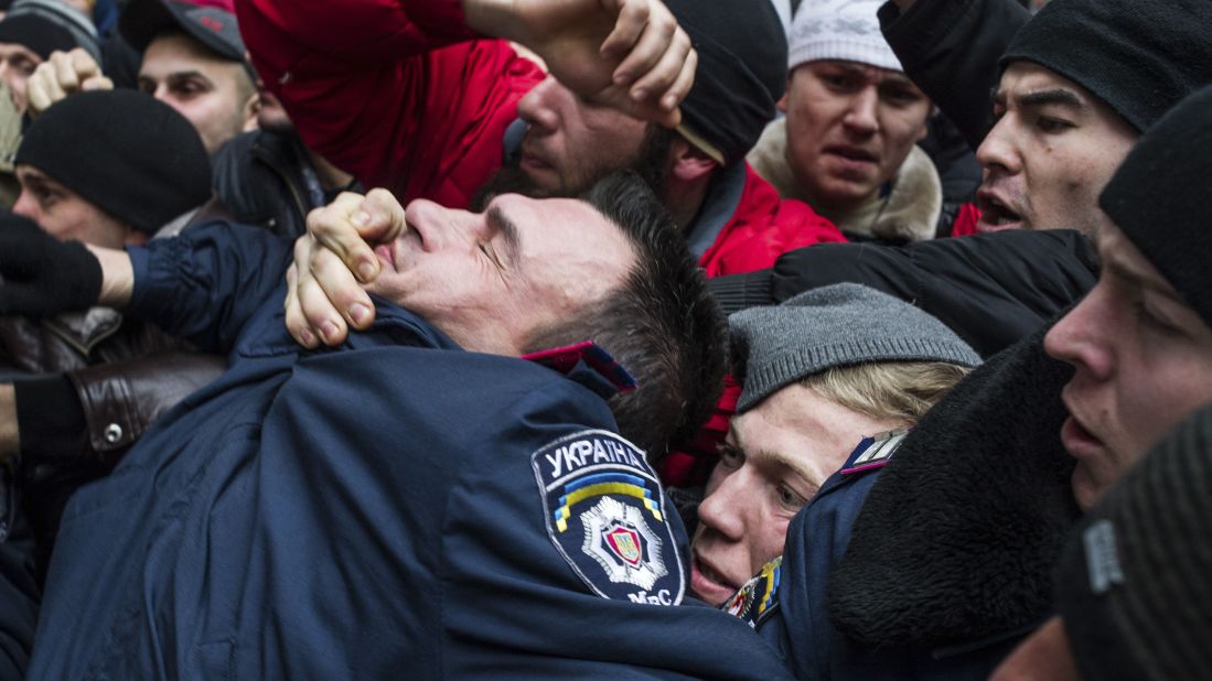A police officer gets pulled into a crowd of Crimean Tatars in Simferopol on February 26. The Tatars, an ethnic minority group deported during the Stalin era, rallied in support of Ukraine's interim government.