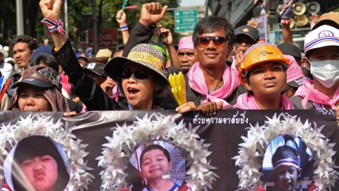 Anti-government protesters march holding posters of child victims of a recent bomb blast in Bangkok.