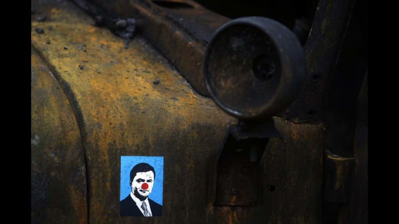 A sticker depicting Ukrainian President Viktor Yanukovych is placed on a burned military truck in Kiev, Ukraine, on Sunday, February 23. Following deadly clashes between anti-government protesters and security forces in Kiev, the country's Parliament <a href="http://www.cnn.com/2014/02/24/world/gallery/ukraine-in-transition/index.html">voted to oust Yanukovych</a> and start shaping a new government.
