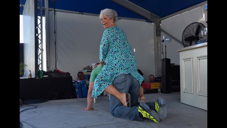 Paula Deen rides fellow celebrity chef Robert Irvine during the South Beach Wine & Food Festival on Sunday, February 23, in Miami Beach, Florida.