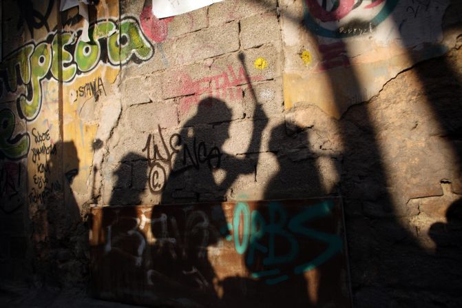 Musicians playing drums cast their shadows on a graffiti-painted wall as they perform during a carnival celebration in Athens, Greece, on Sunday, February 23.