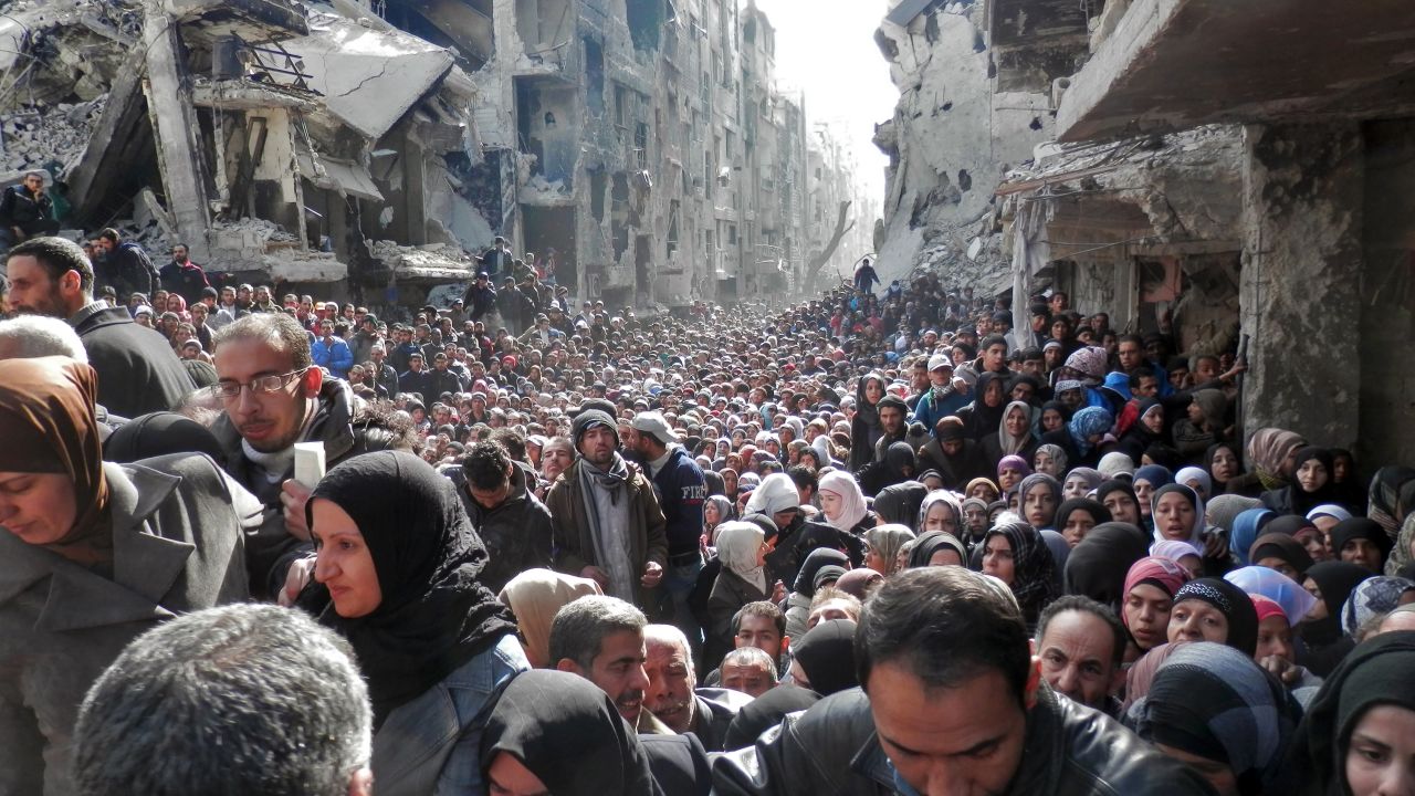 Thousands of residents pack a street in Yarmouk in the hopes of getting food aid in January 2014.