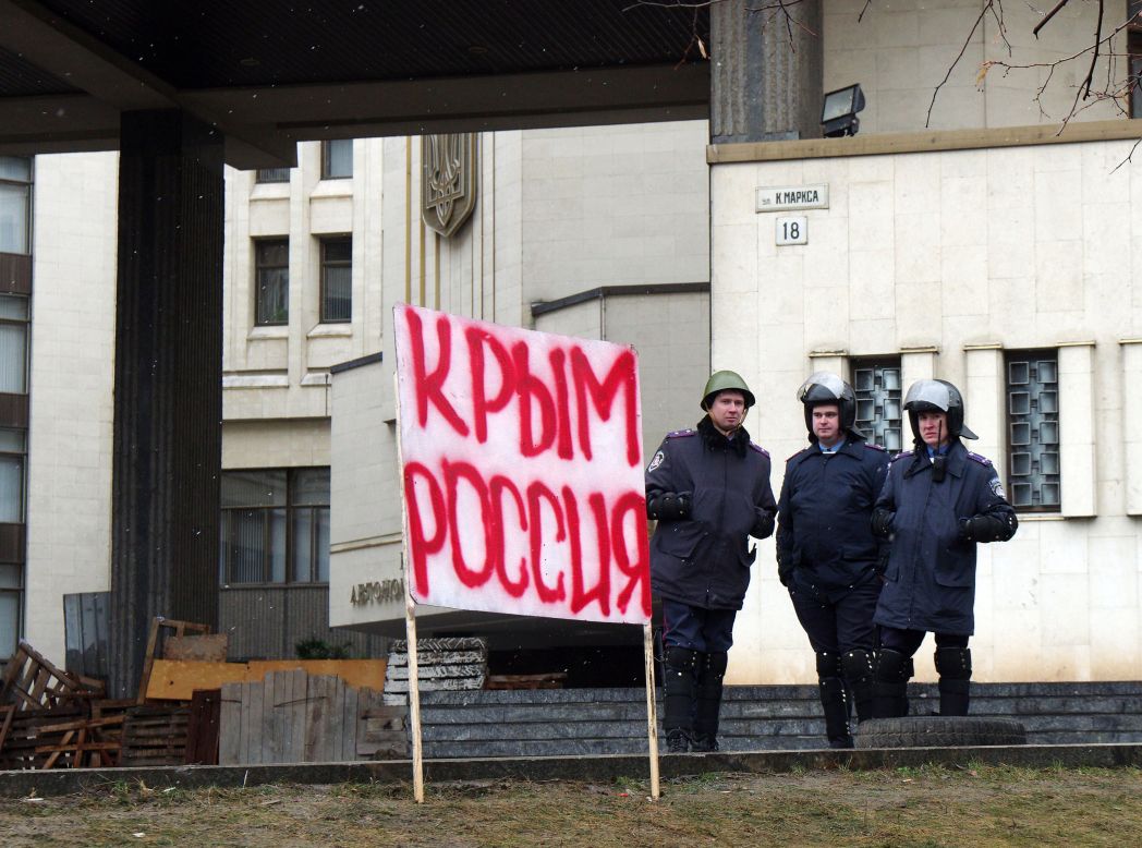 Policías frente al Parlamento de Crimea detrás de un cartel que dice "Crimea es Rusia" en Simferópol on February 27, 2014.