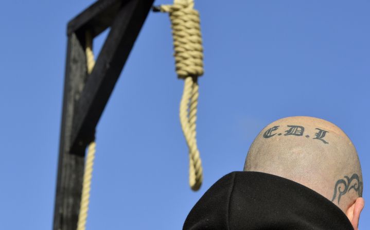 A supporter of the far-right English Defence League stands by a replica of hangman's noose and gallows during a protest outside the Old Bailey courthouse in London on Wednesday, February 26. Two Islamic converts <a href="http://www.cnn.com/2014/02/26/world/europe/uk-soldier-killing-sentencing/index.html">convicted of killing a British soldier</a> on a London street last year were sentenced Wednesday, one to life in prison and the other to a minimum of 45 years.