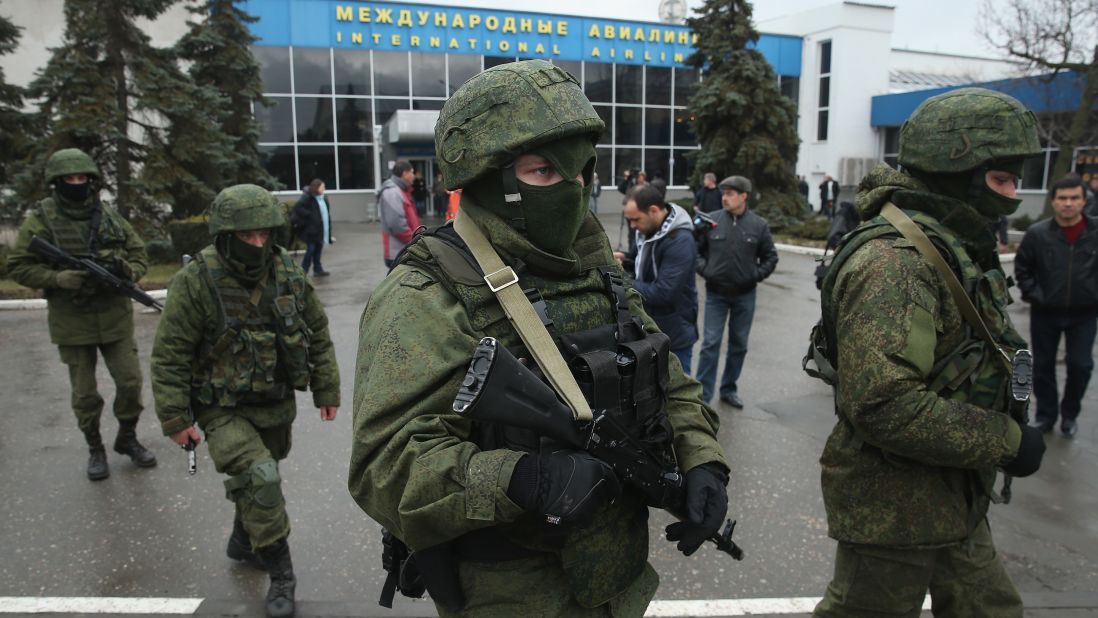 Armed men patrol outside the Simferopol International Airport on Friday, February 28.