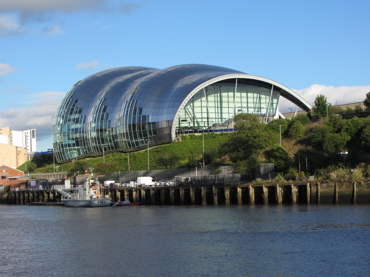 Bajo el manto de cristal curvado, Sage Gateshead alberga tres salas de conciertos de diferentes tamaños, todas equipadas con tecnología de punta. Desde su finalización en el 2004, el complejo de eventos de forma orgánica ha sido una atracción de la zona de Newcastle al norte de Inglaterra. Arquitecto: Foster + Partners.